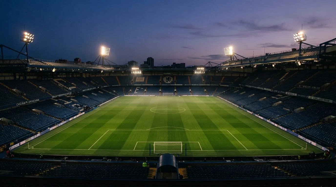 Een leeg voetbalstadion met lichtmasten bij schemering